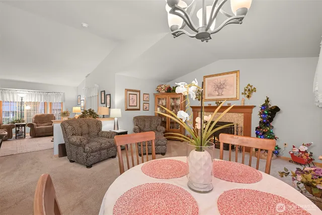 a living room with furniture a chandelier and a dining table