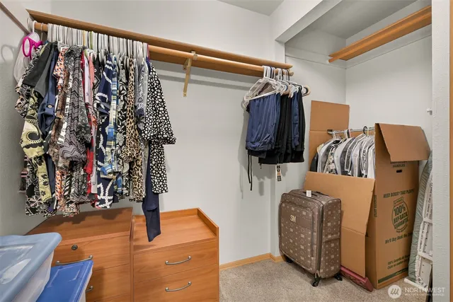 a view of walk in closet with clothes and shoes