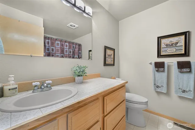a bathroom with a granite countertop sink mirror and toilet