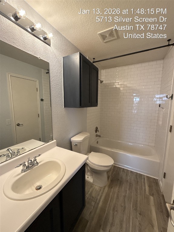 5713 Silver Screen Drive Austin, TX 78747 - Photo 10 of 21 Bathroom featuring shower / washtub combination, a textured wall, vanity, a textured ceiling, and dark wood finished floors