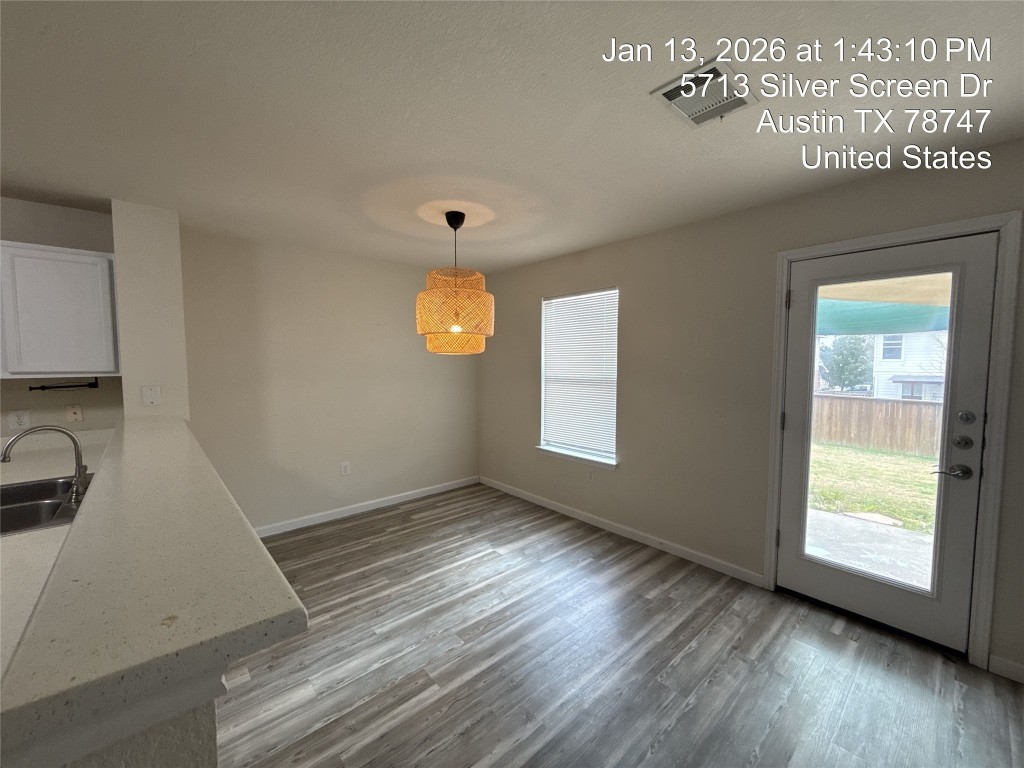 5713 Silver Screen Drive Austin, TX 78747 - Photo 3 of 21 Unfurnished dining area with dark wood-style flooring