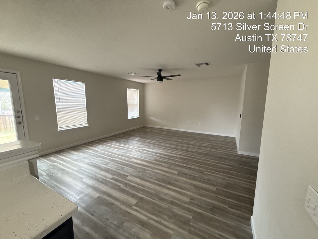 5713 Silver Screen Drive Austin, TX 78747 - Photo 4 of 21 Empty room featuring dark wood-style flooring and a ceiling fan