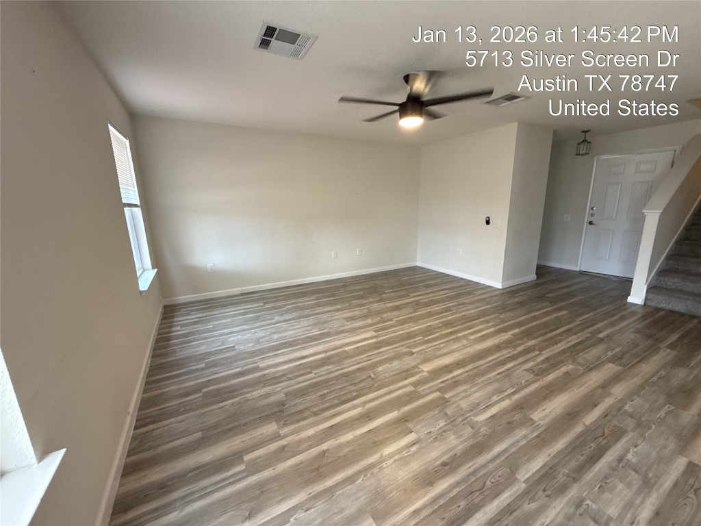 5713 Silver Screen Drive Austin, TX 78747 - Photo 5 of 21 Spare room featuring stairway, wood finished floors, and a ceiling fan