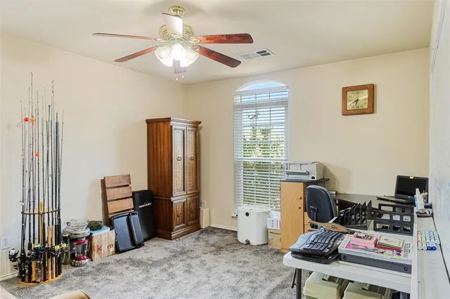 a view of a workspace with furniture and a window