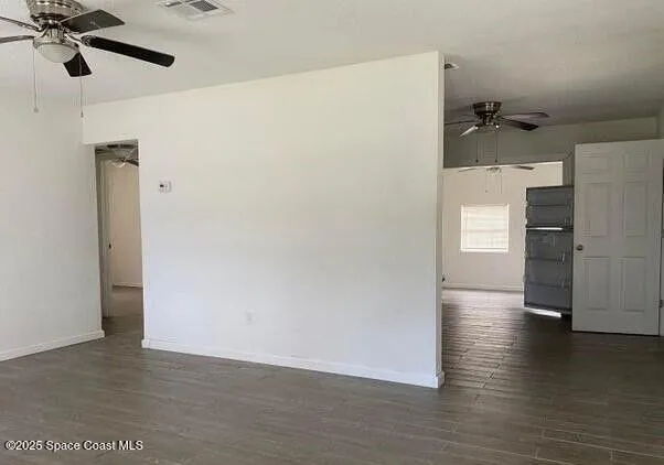 a view of a kitchen with a refrigerator and wooden floor