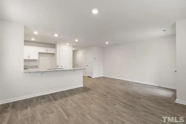 a view of kitchen with kitchen island wooden floor appliances and cabinets