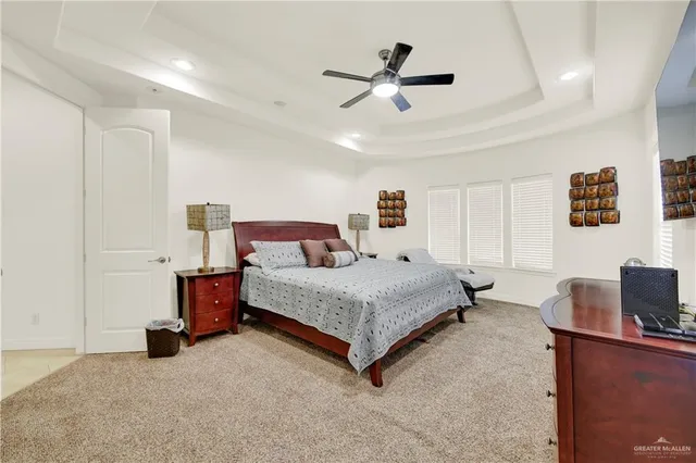 a spacious bedroom with a bed and a ceiling fan