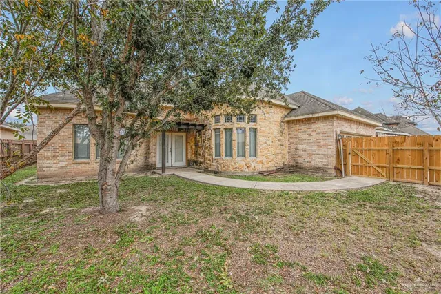 a view of a house with a tree and a yard