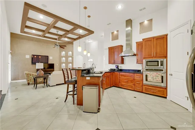 a kitchen with stainless steel appliances kitchen island granite countertop a refrigerator a stove a sink and dishwasher