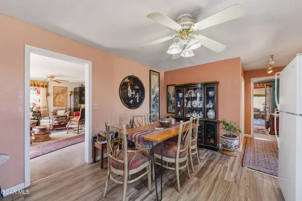 a view of a dining room and livingroom with furniture wooden floor and a chandelier