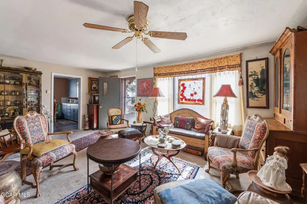 a living room with furniture kitchen view and a window