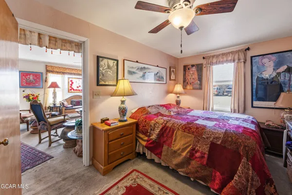 a bedroom with a bed and dresser with the view of chandelier