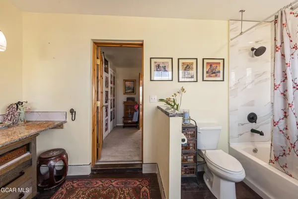 a bathroom with a granite countertop toilet a sink and a shower