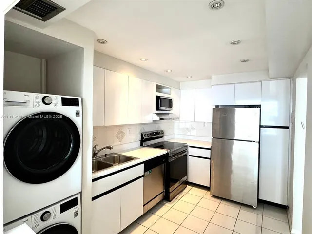 a kitchen with a refrigerator sink stove and cabinets