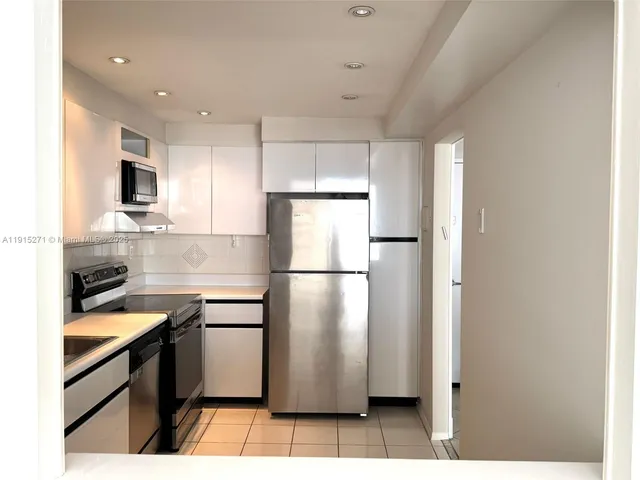 a kitchen with a refrigerator a sink and cabinets