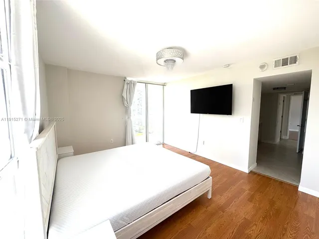 a bedroom with a bed and a flat screen tv
