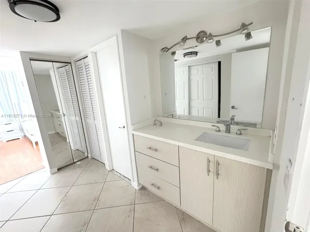 a spacious bathroom with a double vanity sink a mirror and a