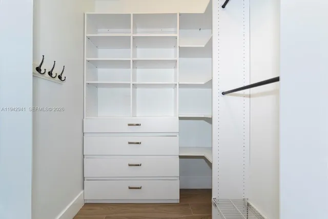 a view of walk in closet with empty racks