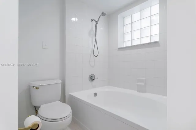 a white bath tub sitting next to a toilet