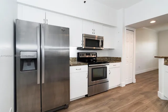 a kitchen with stainless steel appliances a refrigerator stove and microwave