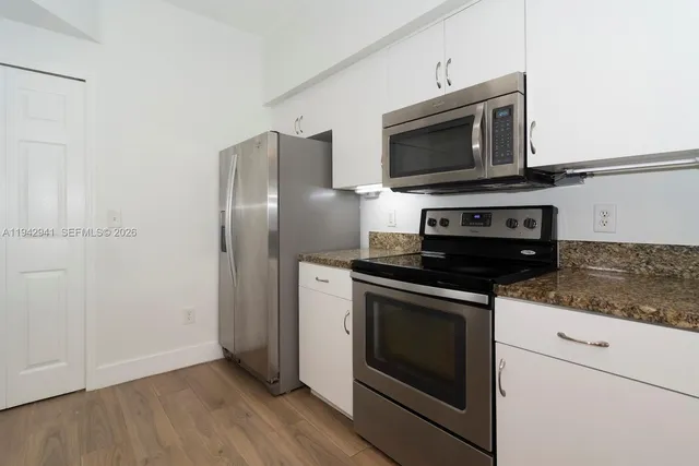 a kitchen with stainless steel appliances granite countertop a stove microwave and refrigerator