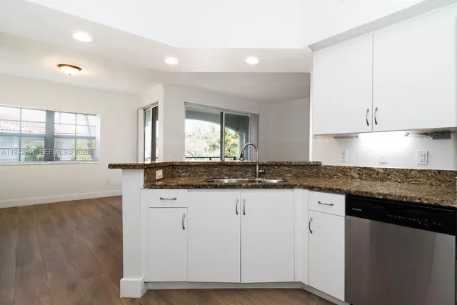 a kitchen with granite countertop a sink and a stove