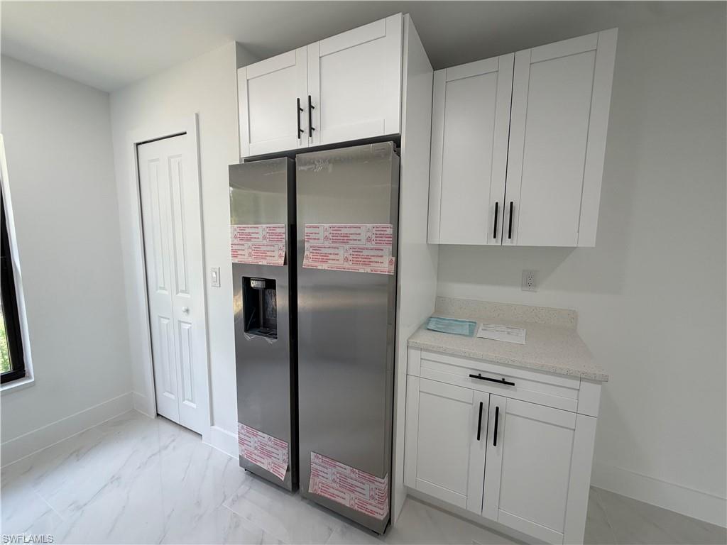 15 Louisiana Road Lehigh Acres, FL 33936 - Photo 8 of 22 a kitchen with a refrigerator and cabinets