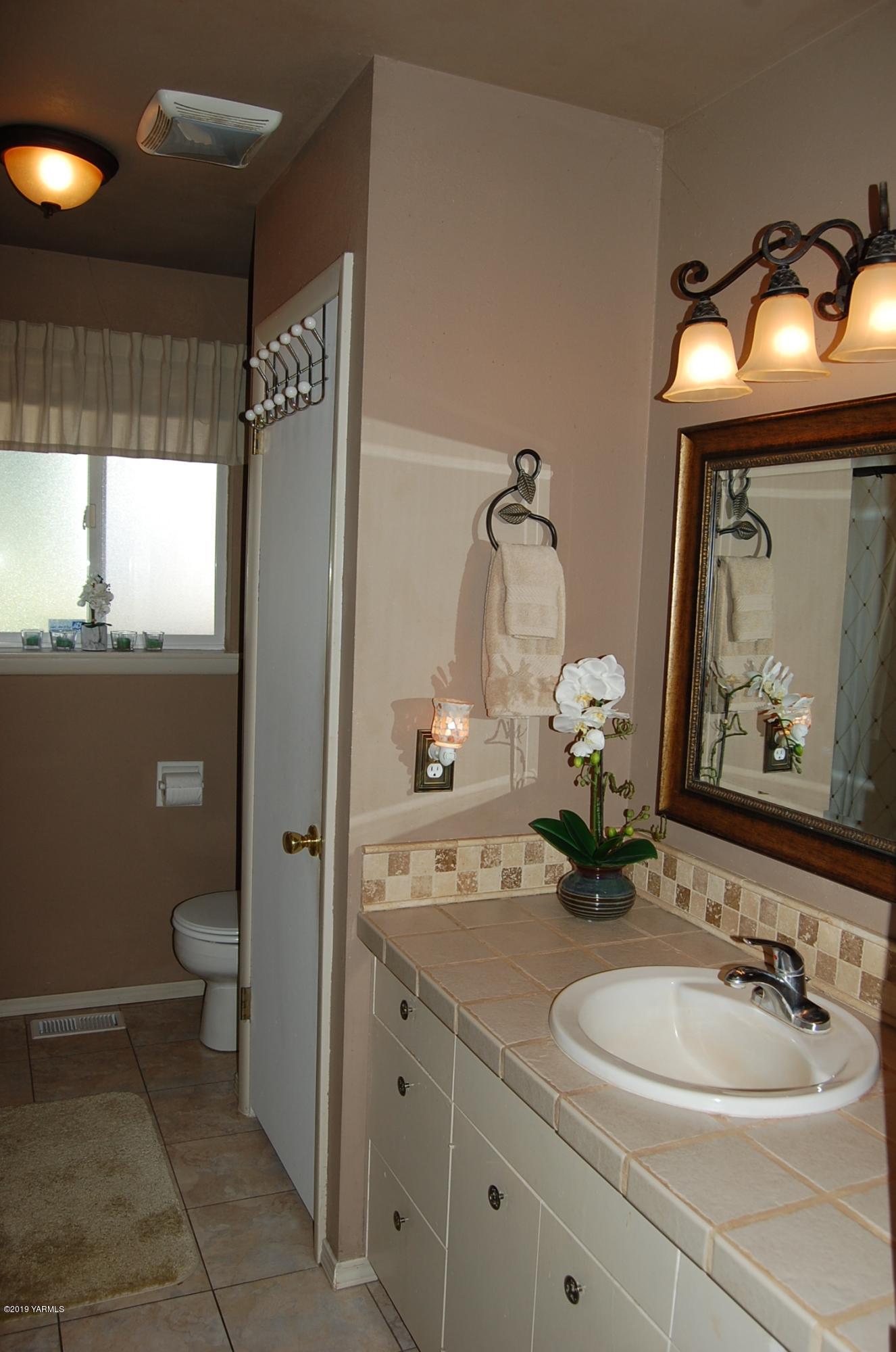 2710 Nelson Road Yakima, WA 98903 - Photo 16 of 30 a bathroom with a toilet sink and mirror