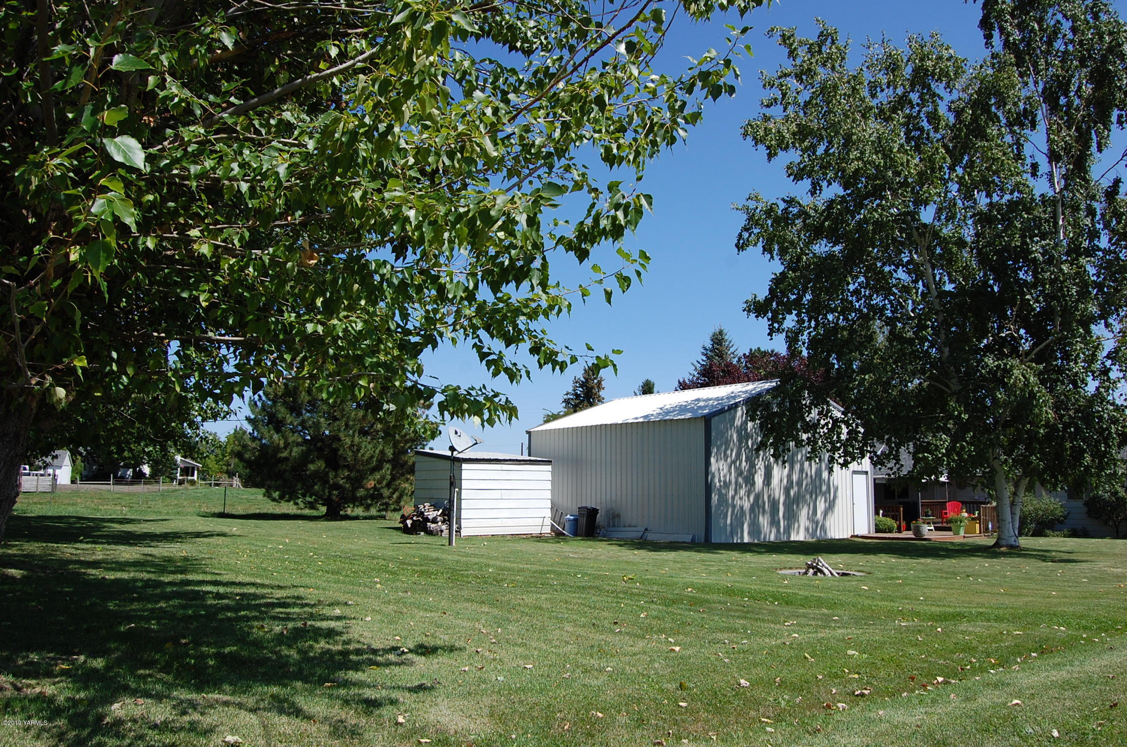 2710 Nelson Road Yakima, WA 98903 - Photo 25 of 30 a view of a white house with a yard and trees