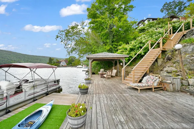 a view of patio with table and chairs under an umbrella with a small yard