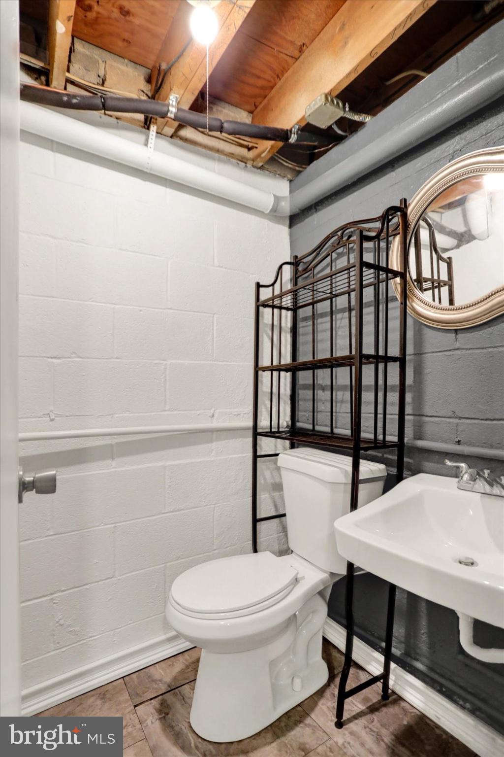 959 Elm Road Baltimore, MD 21227 - Photo 18 of 27 a white toilet sitting next to a bathroom sink