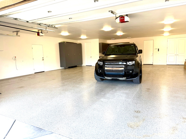 1500 Split Rock, Unit 150 Ivins, UT 84738 - Photo 18 of 18 Spacious garage featuring a speckled epoxy floor, multiple overhead lights, automatic garage door openers, and built-in storage cabinetry