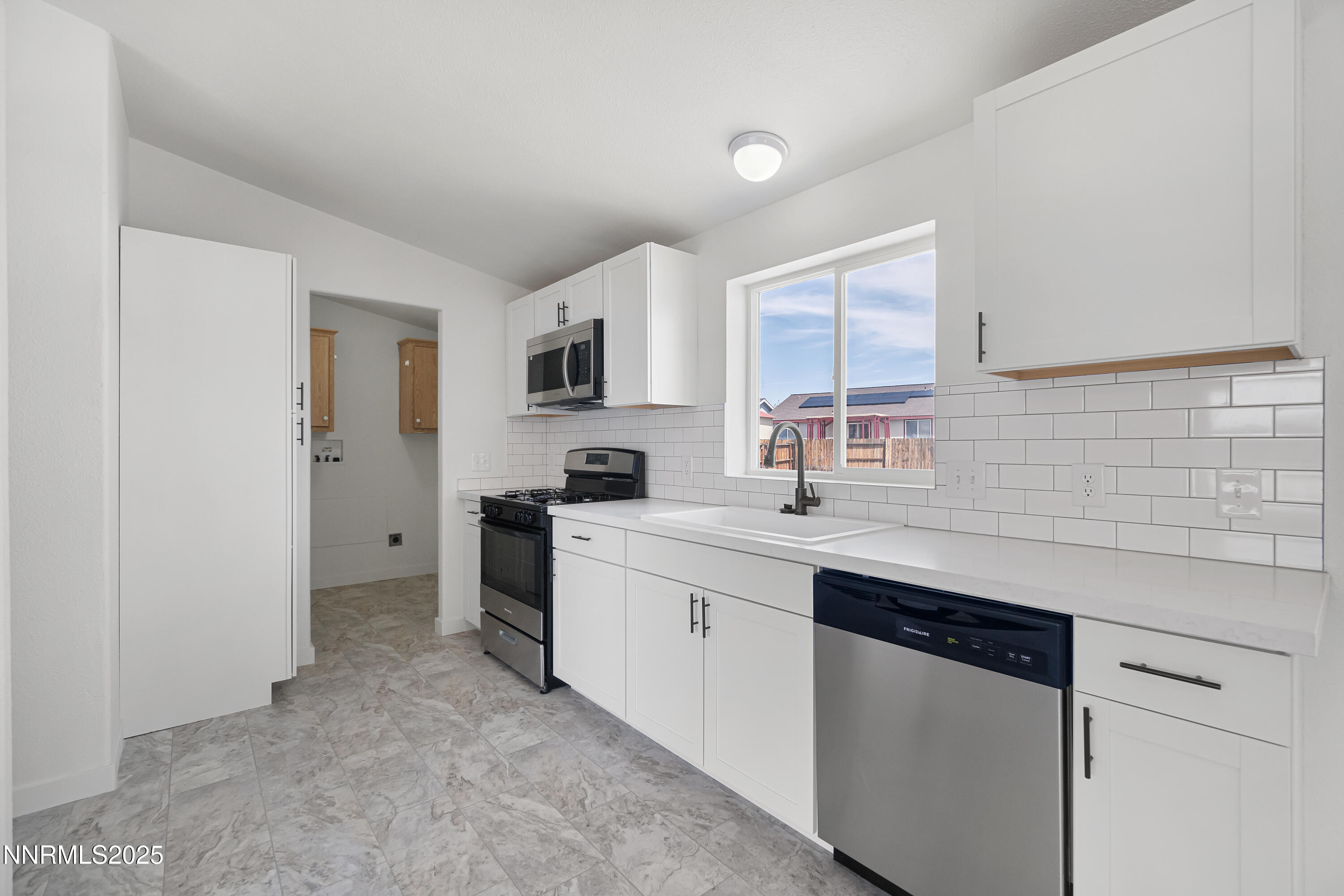 863 Jennys Lane Fernley, NV 89408 - Photo 13 of 24 a kitchen with a sink cabinets stainless steel appliances and a window