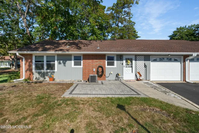 a view of a house with a yard and large tree