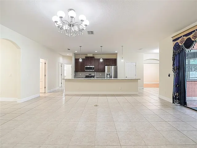 an empty room with wooden floor cabinet and windows
