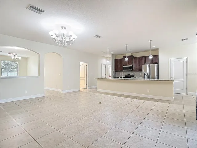 a kitchen with stainless steel appliances granite countertop a sink a refrigerator and a granite counter tops