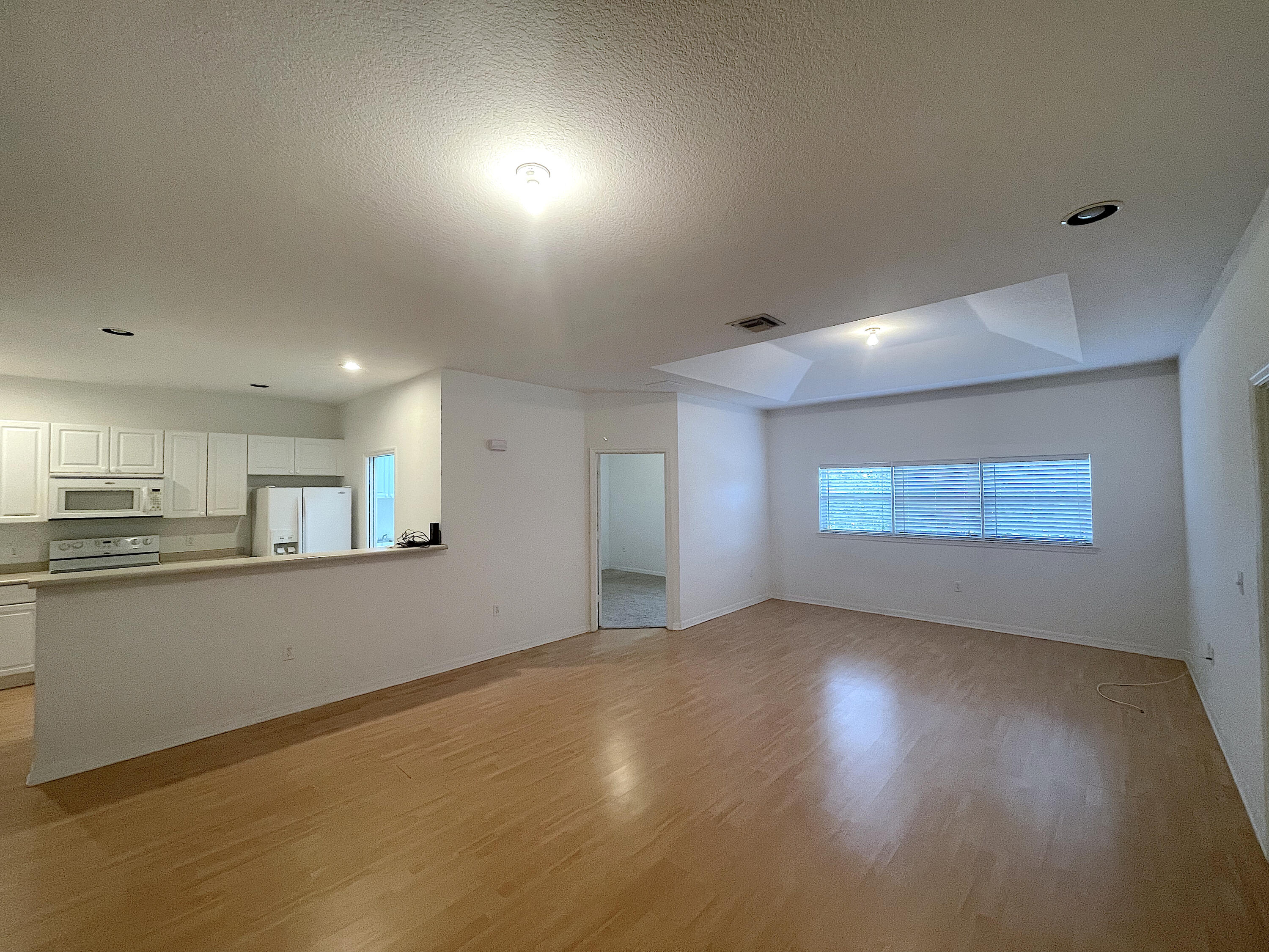 1791 Lakefront Boulevard, Unit 1 Fort Pierce, FL 34982 - Photo 2 of 14 a view of empty room with wooden floor and kitchen
