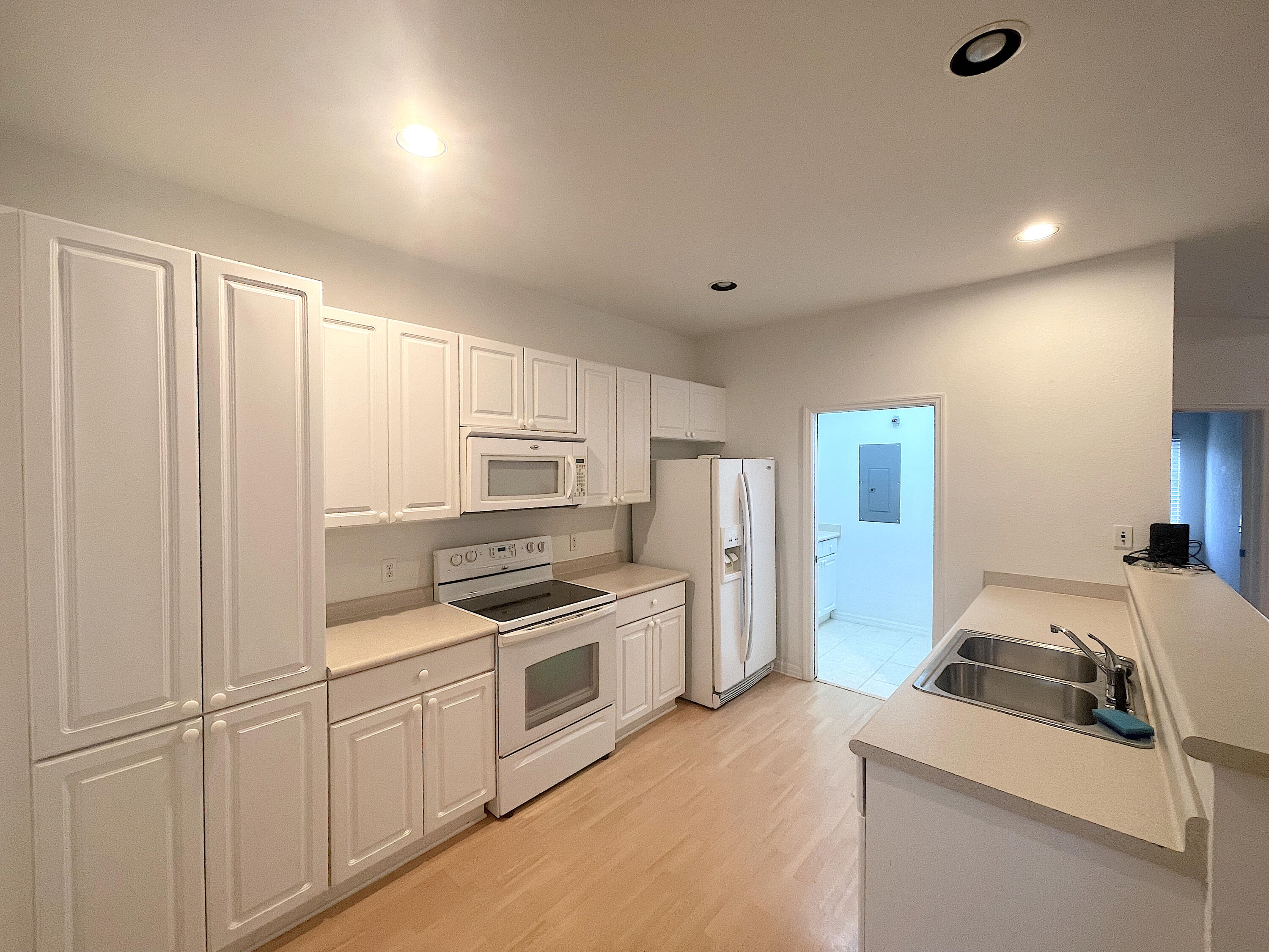 1791 Lakefront Boulevard, Unit 1 Fort Pierce, FL 34982 - Photo 5 of 14 a kitchen with white cabinets and stainless steel appliances