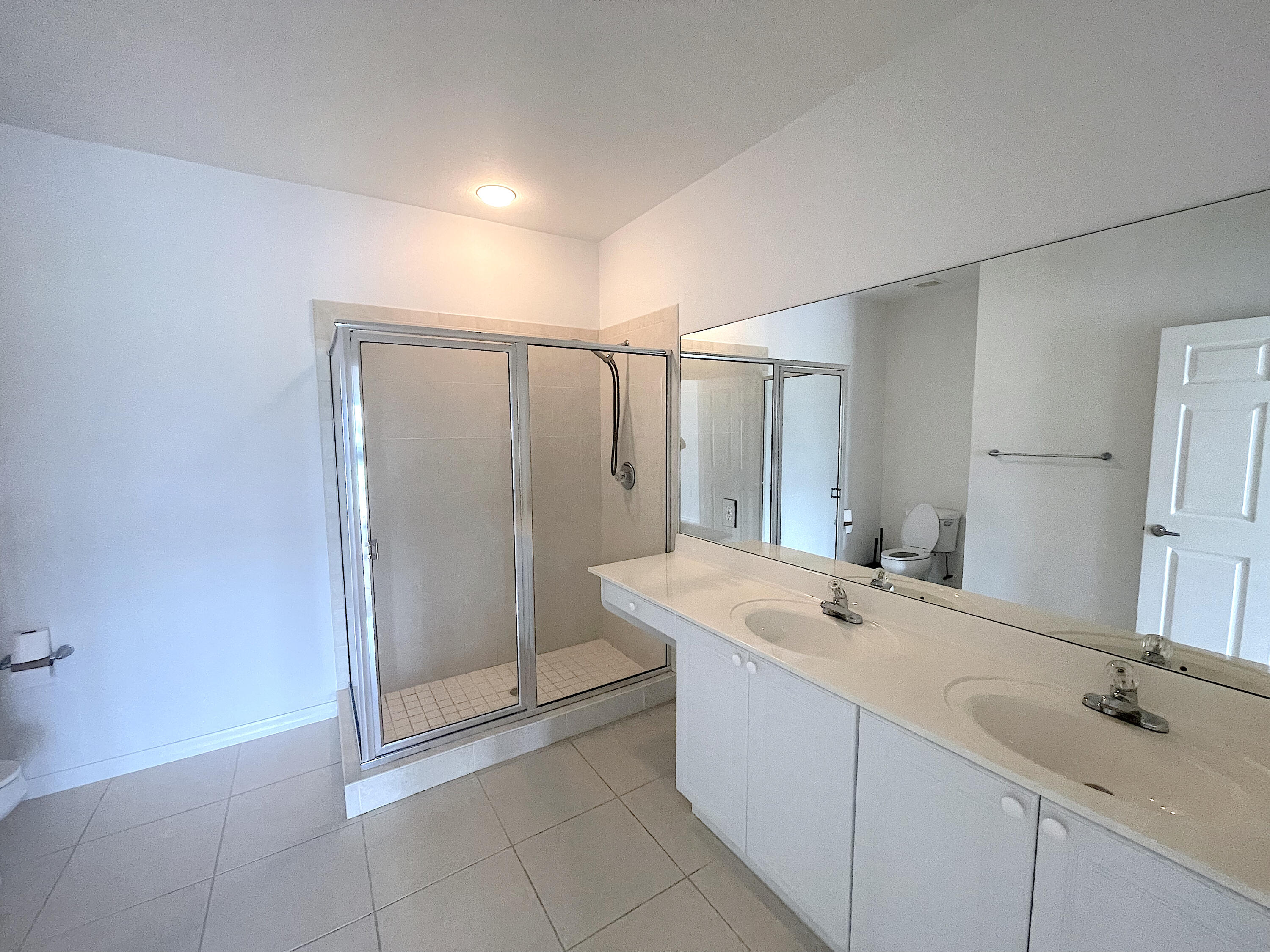 1791 Lakefront Boulevard, Unit 1 Fort Pierce, FL 34982 - Photo 10 of 14 a bathroom with a double vanity sink mirror and shower