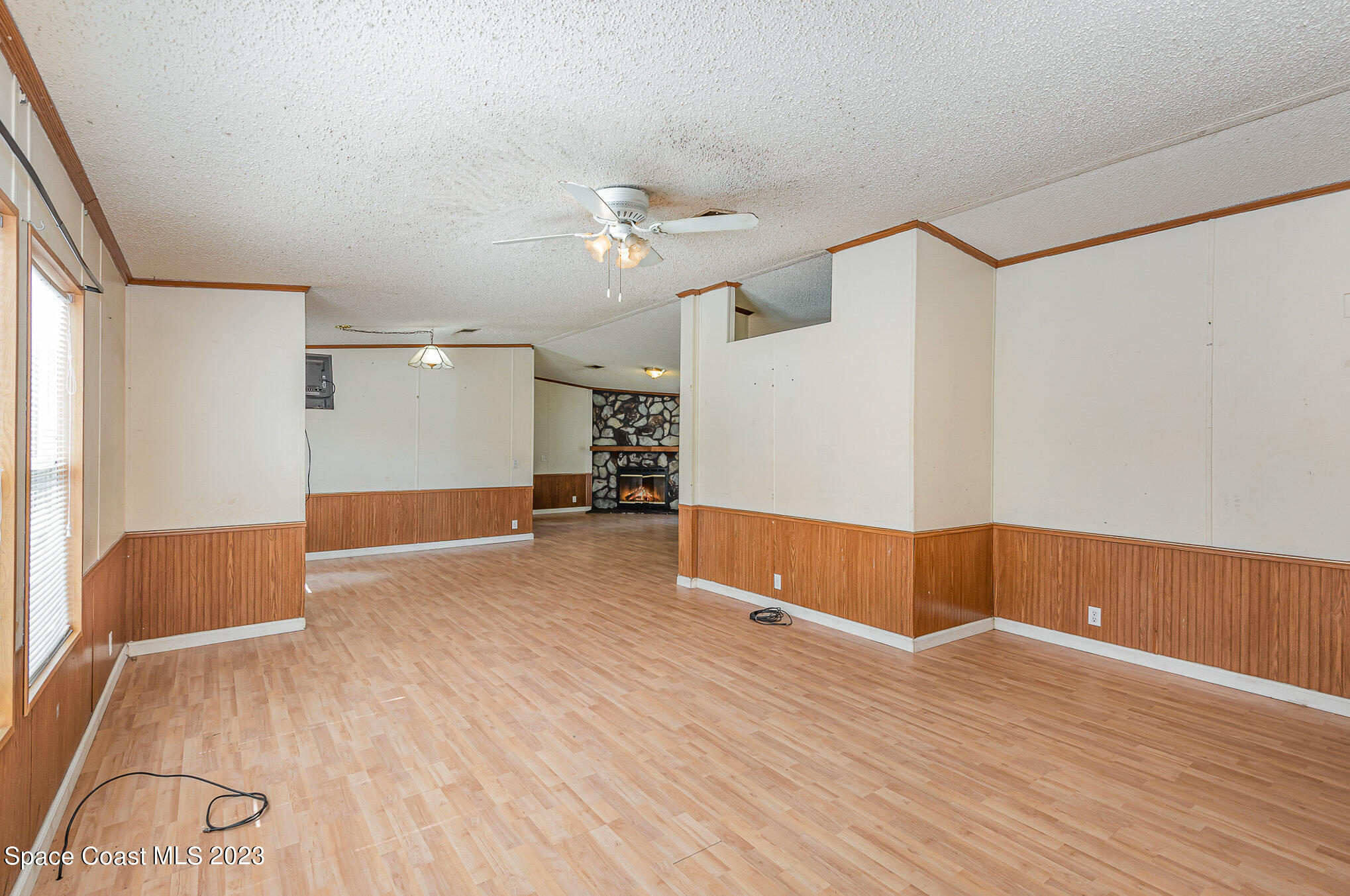 823 Phyllis Way Cocoa, FL 32926 - Photo 6 of 28 a view of an empty room with wooden floor and a ceiling fan