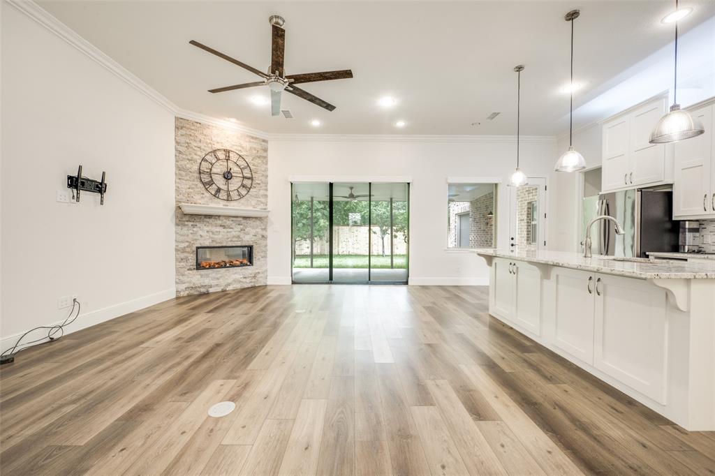 444 Ben Boyd Road Argyle, TX 76226 - Photo 7 of 28 a large kitchen with kitchen island a stove a refrigerator a sink and dishwasher with wooden floor