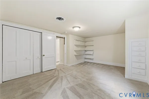 a view of a room with walk in closet and empty racks