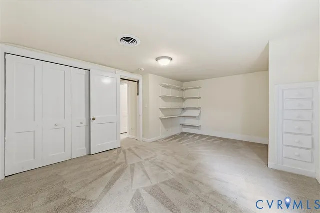 a view of a room with walk in closet and empty racks