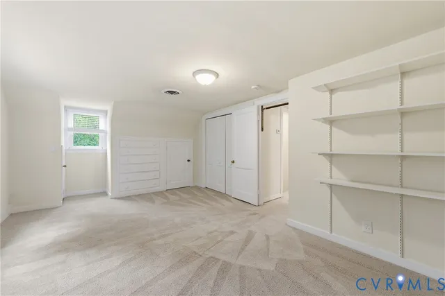 a view of an empty room with cabinet and entryway