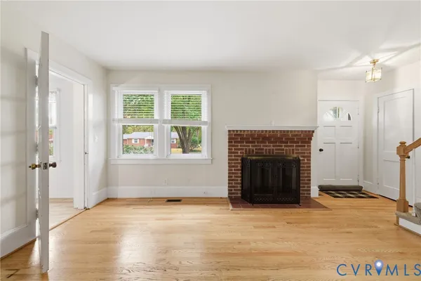 an empty room with windows and fireplace
