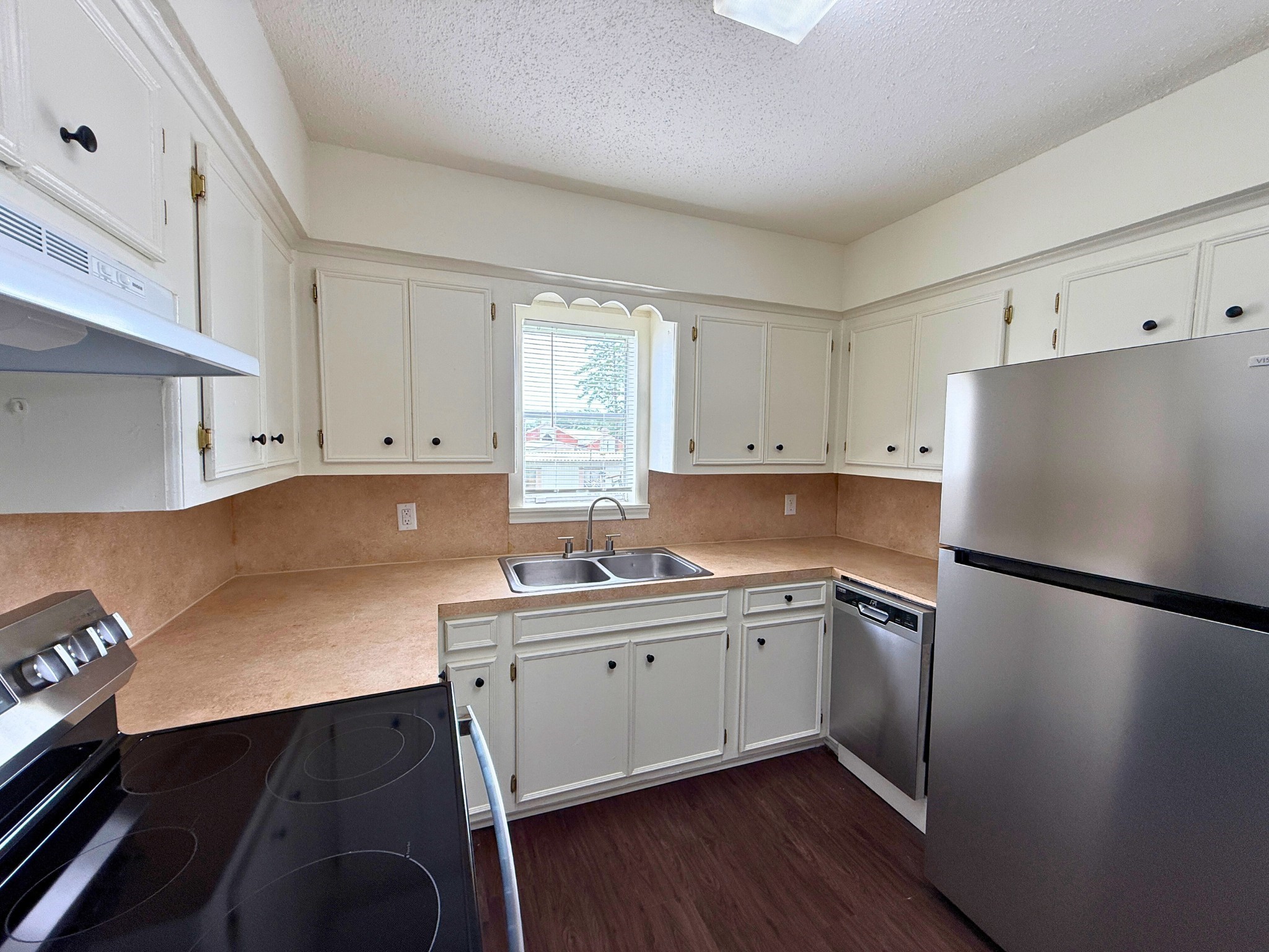 214 Crawford Street Huntsville, TX 77340 - Photo 17 of 24 a kitchen with a sink a refrigerator and cabinets