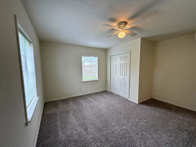 a view of a livingroom with a ceiling fan and window