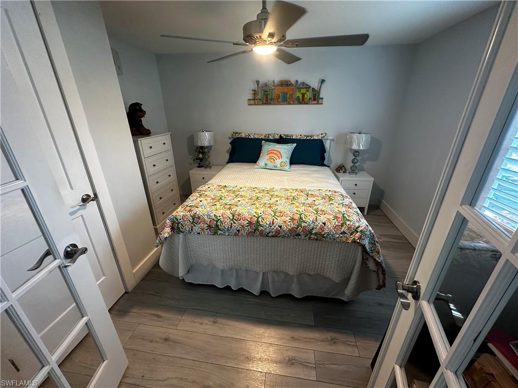 170 Pine Key Lane, Unit 13 Naples, FL 34114 - Photo 14 of 34 Bedroom with light wood-style floors and a ceiling fan