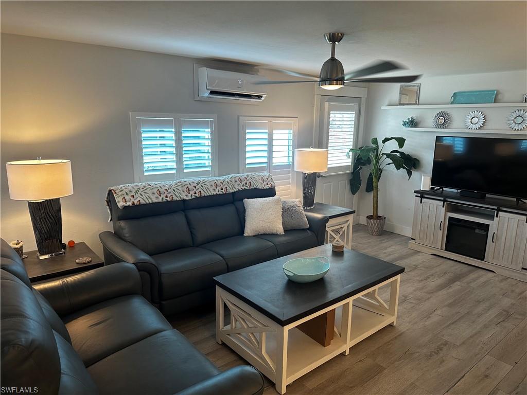 170 Pine Key Lane, Unit 13 Naples, FL 34114 - Photo 17 of 34 Living room with a ceiling fan, a mini split for heating / cooling, and wood finished floors