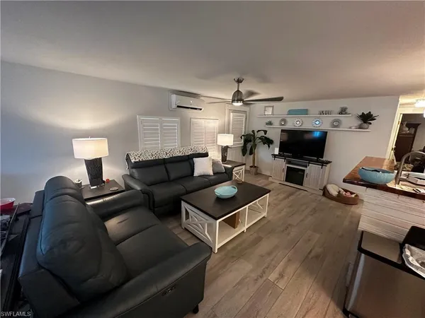 a living room with furniture a flat screen tv and kitchen view